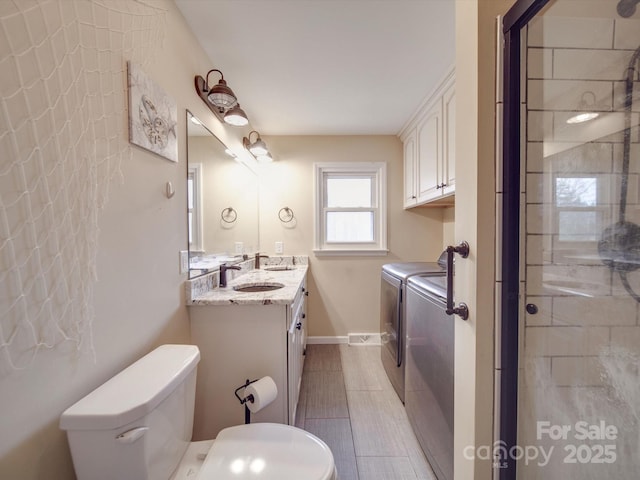 bathroom with tile patterned flooring, vanity, independent washer and dryer, and toilet