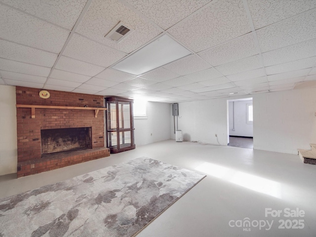 basement featuring a paneled ceiling and a fireplace