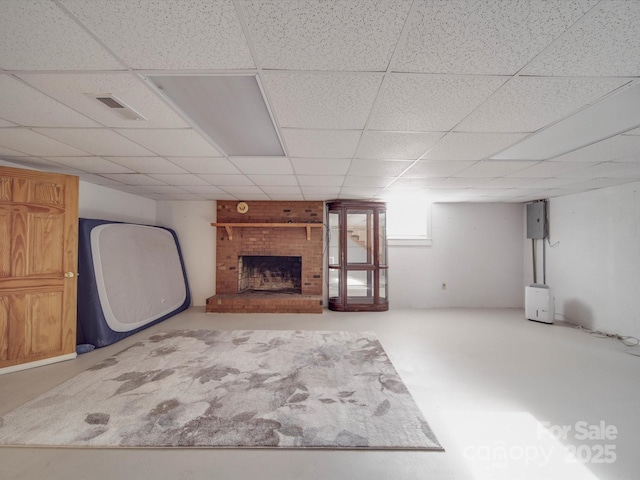 basement with a brick fireplace and a paneled ceiling