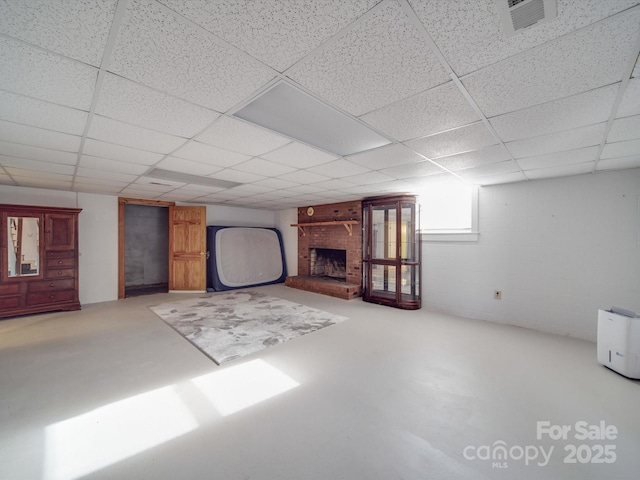 basement featuring a drop ceiling and a fireplace