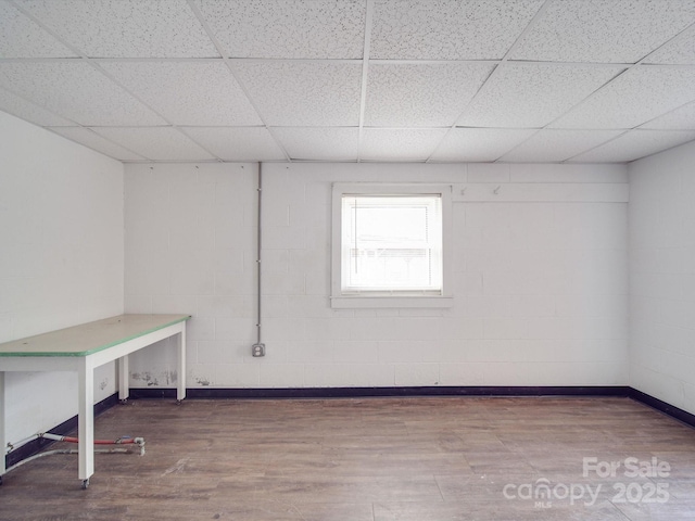 basement with hardwood / wood-style floors and a drop ceiling