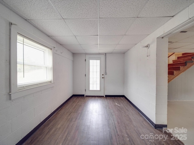 unfurnished room featuring dark wood-type flooring and a paneled ceiling