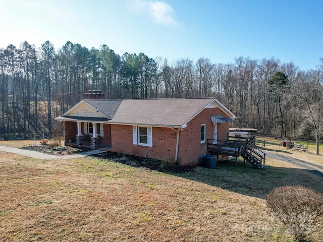 view of front of house with central AC and a front lawn