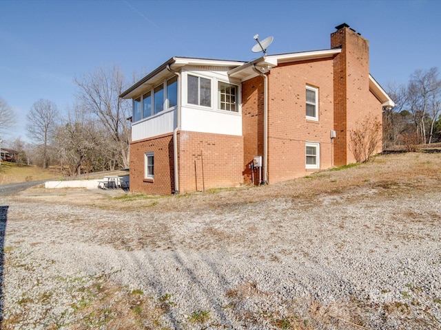 view of property exterior with a sunroom