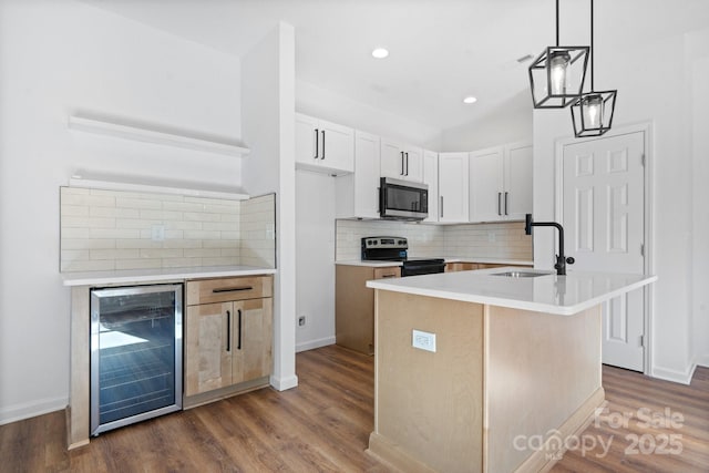 kitchen with white cabinetry, decorative light fixtures, an island with sink, range with electric cooktop, and beverage cooler