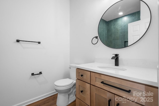 bathroom featuring hardwood / wood-style flooring, vanity, and toilet