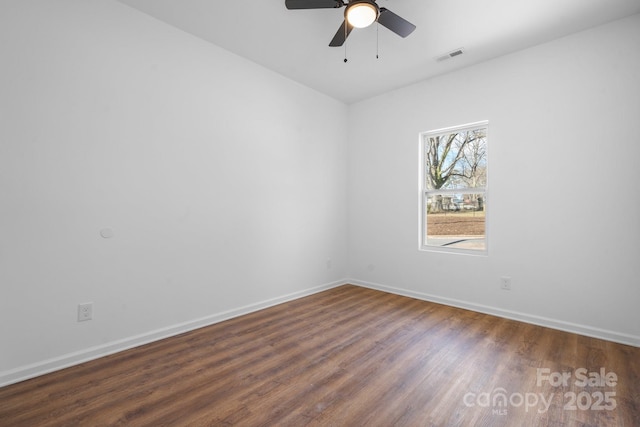 spare room featuring dark wood-type flooring and ceiling fan