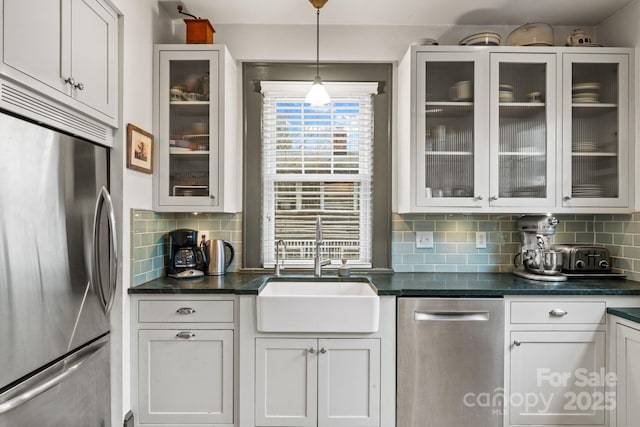 kitchen featuring appliances with stainless steel finishes, decorative light fixtures, sink, and white cabinets