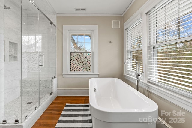 bathroom featuring plus walk in shower, sink, hardwood / wood-style floors, and crown molding