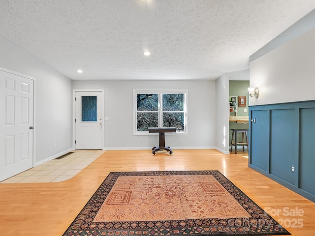 entrance foyer featuring light hardwood / wood-style floors and a textured ceiling