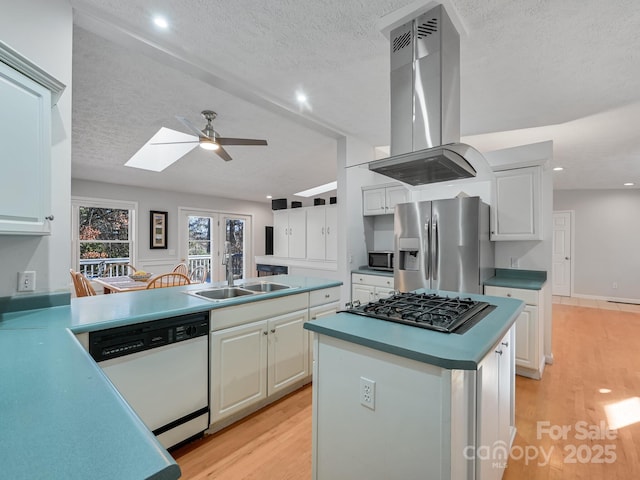 kitchen with a kitchen island, appliances with stainless steel finishes, white cabinetry, sink, and island exhaust hood