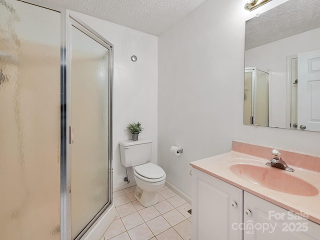 bathroom with vanity, a shower with shower door, tile patterned floors, and a textured ceiling