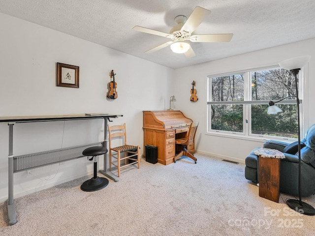 misc room with light carpet, ceiling fan, and a textured ceiling