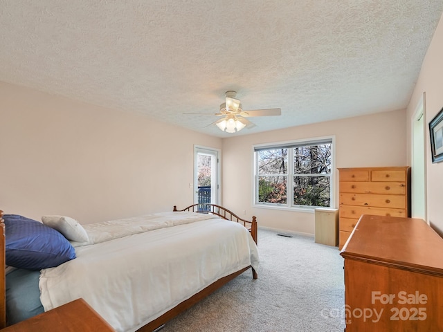 carpeted bedroom with ceiling fan and a textured ceiling