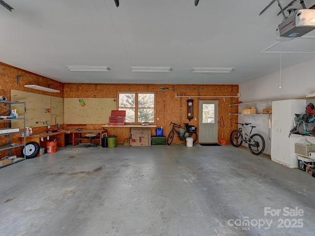 garage featuring a garage door opener and a workshop area