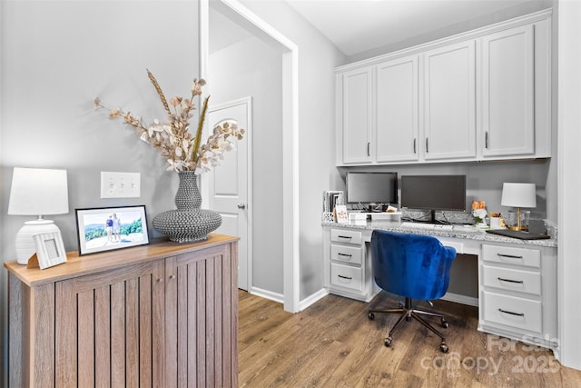 office area with built in desk and light hardwood / wood-style flooring