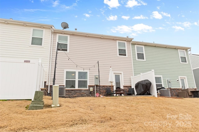 back of house featuring a yard and central air condition unit