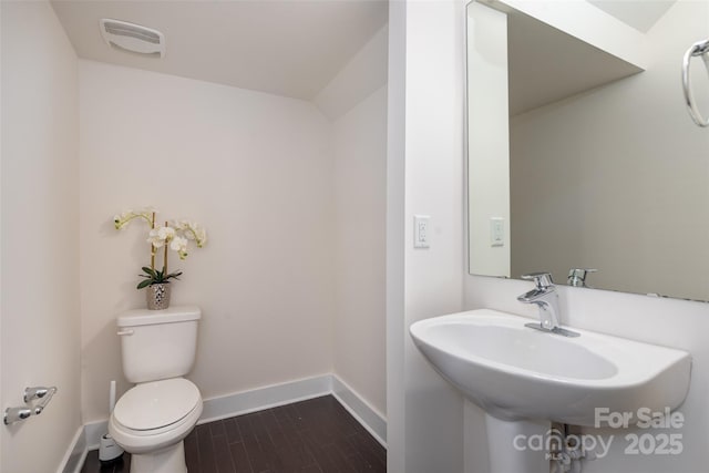 bathroom with sink, toilet, and hardwood / wood-style floors