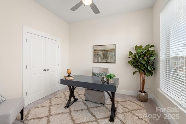 carpeted office featuring ceiling fan