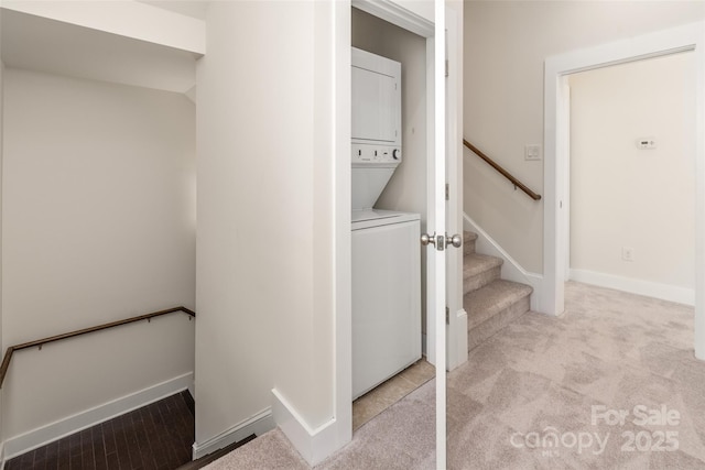 clothes washing area with light colored carpet and stacked washer / dryer