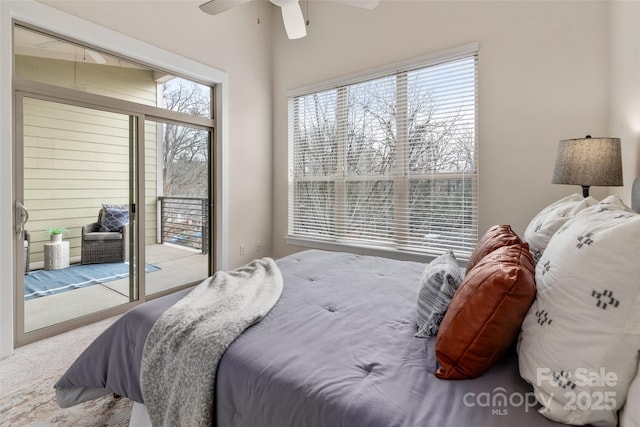 carpeted bedroom featuring multiple windows, access to exterior, and ceiling fan