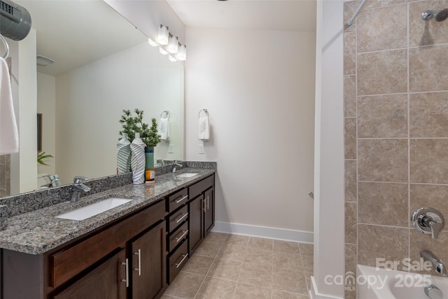 bathroom with tiled shower / bath, vanity, and tile patterned flooring