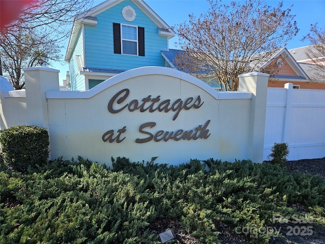 community / neighborhood sign with fence