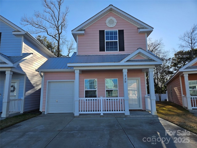 traditional home featuring a garage, covered porch, metal roof, and concrete driveway