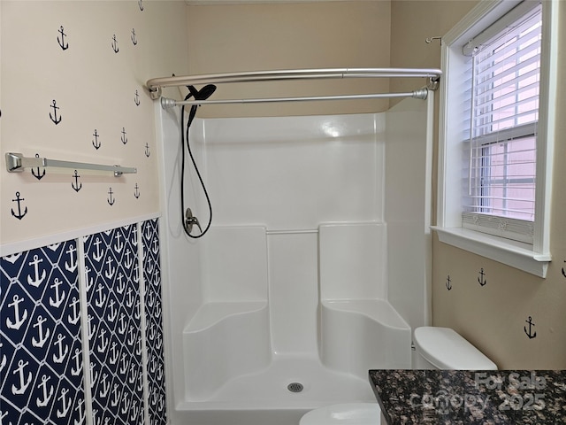 bathroom with toilet and a shower stall