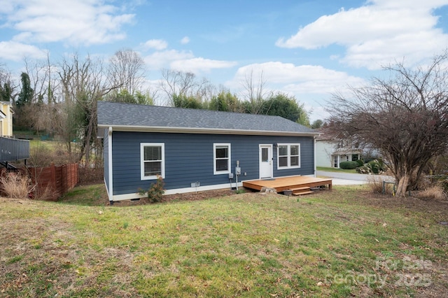 rear view of house with a wooden deck and a yard