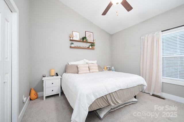 carpeted bedroom with ceiling fan and vaulted ceiling