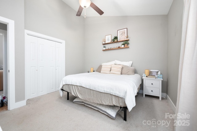 bedroom featuring light carpet, ceiling fan, vaulted ceiling, and a closet