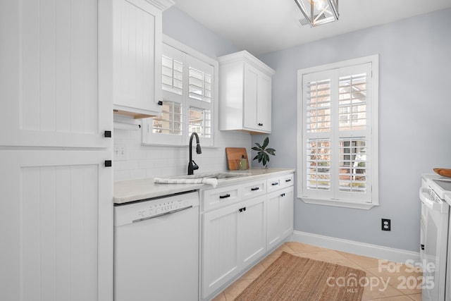 kitchen with light tile patterned flooring, sink, white appliances, decorative backsplash, and white cabinets