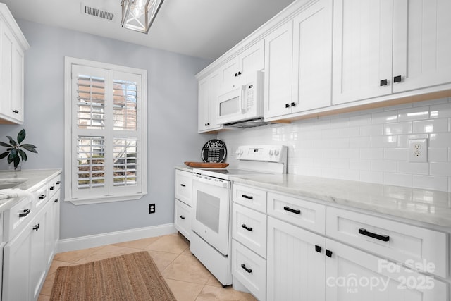 kitchen featuring light tile patterned floors, white appliances, white cabinetry, light stone counters, and decorative backsplash