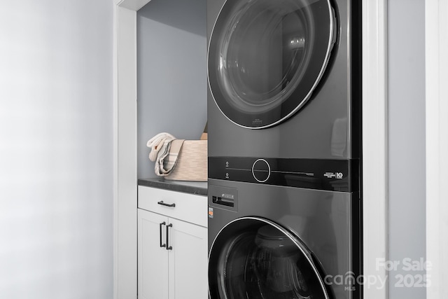 laundry room with cabinets and stacked washer / drying machine