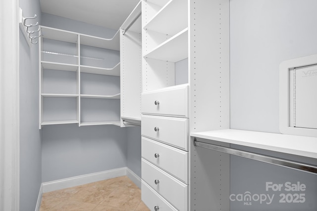 spacious closet with light tile patterned floors