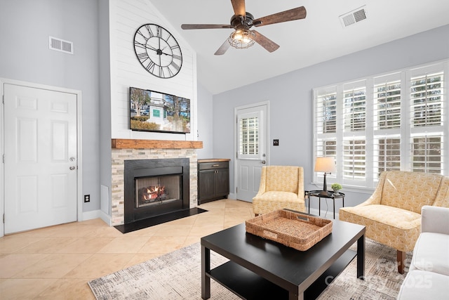 living room with ceiling fan, a large fireplace, high vaulted ceiling, and light tile patterned floors