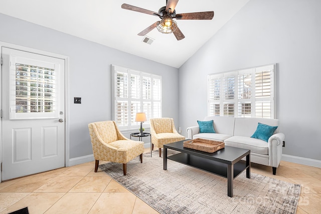 living area with vaulted ceiling, light tile patterned floors, and ceiling fan