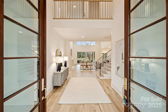 entryway featuring a high ceiling and light wood-type flooring