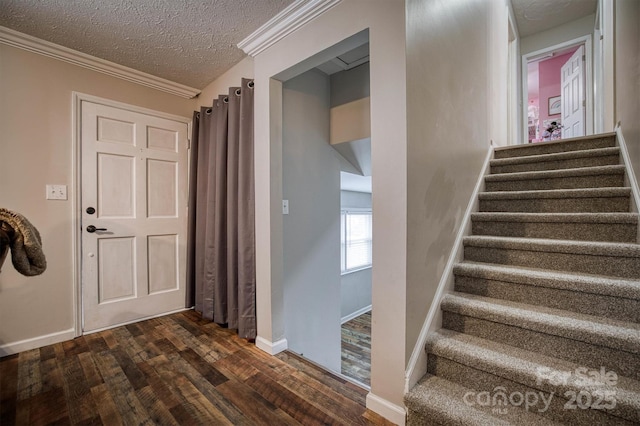 entrance foyer with crown molding, dark hardwood / wood-style flooring, and a textured ceiling