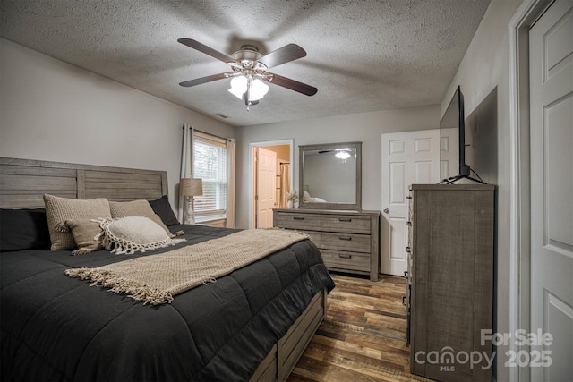 bedroom with ceiling fan, ensuite bathroom, dark hardwood / wood-style floors, and a textured ceiling