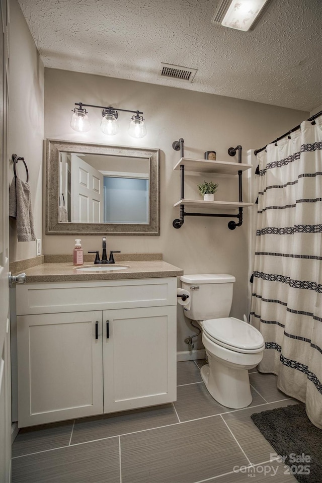 bathroom featuring vanity, a shower with shower curtain, a textured ceiling, and toilet