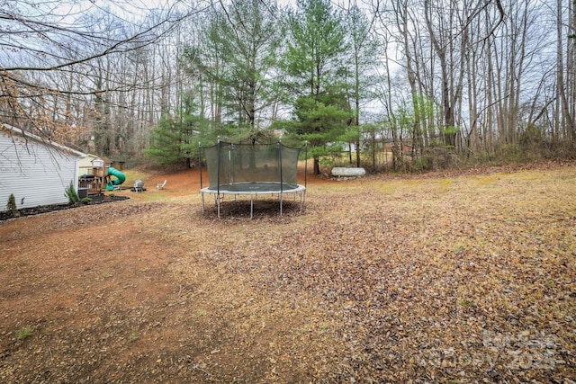 view of yard featuring a trampoline and a playground