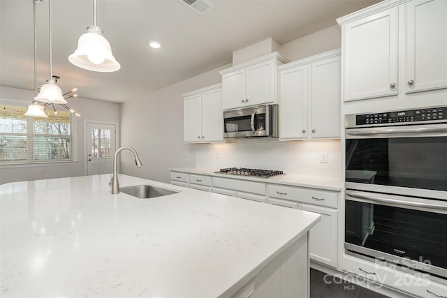 kitchen with stainless steel appliances, sink, and white cabinets