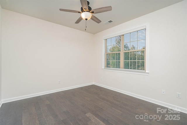 empty room with ceiling fan and dark hardwood / wood-style flooring