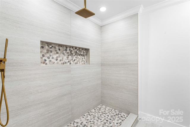 bathroom with a tile shower and crown molding