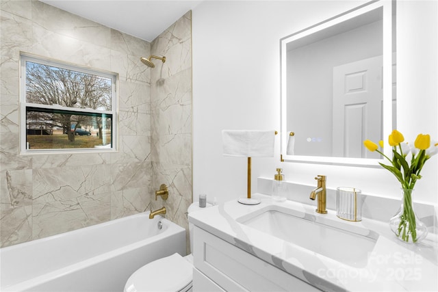 full bathroom featuring vanity, tiled shower / bath combo, and toilet