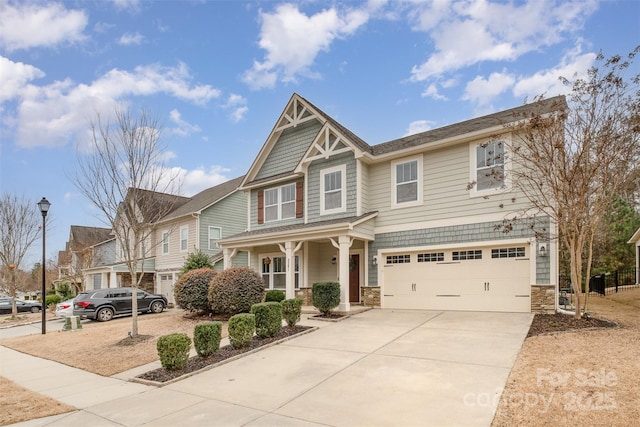 2201 Bluebell Way, Tega Cay, SC 29708 - craftsman-style home with a garage, concrete driveway, stone siding, and covered porch