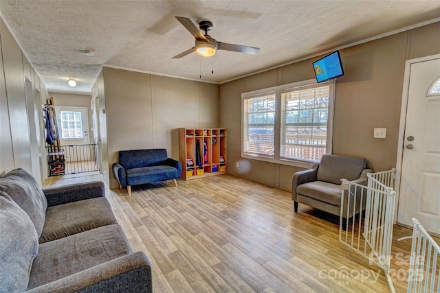 sitting room featuring ceiling fan, hardwood / wood-style flooring, and a textured ceiling