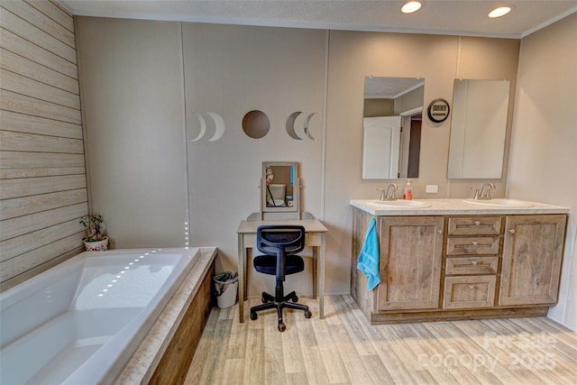 bathroom with vanity, a tub to relax in, and wood-type flooring